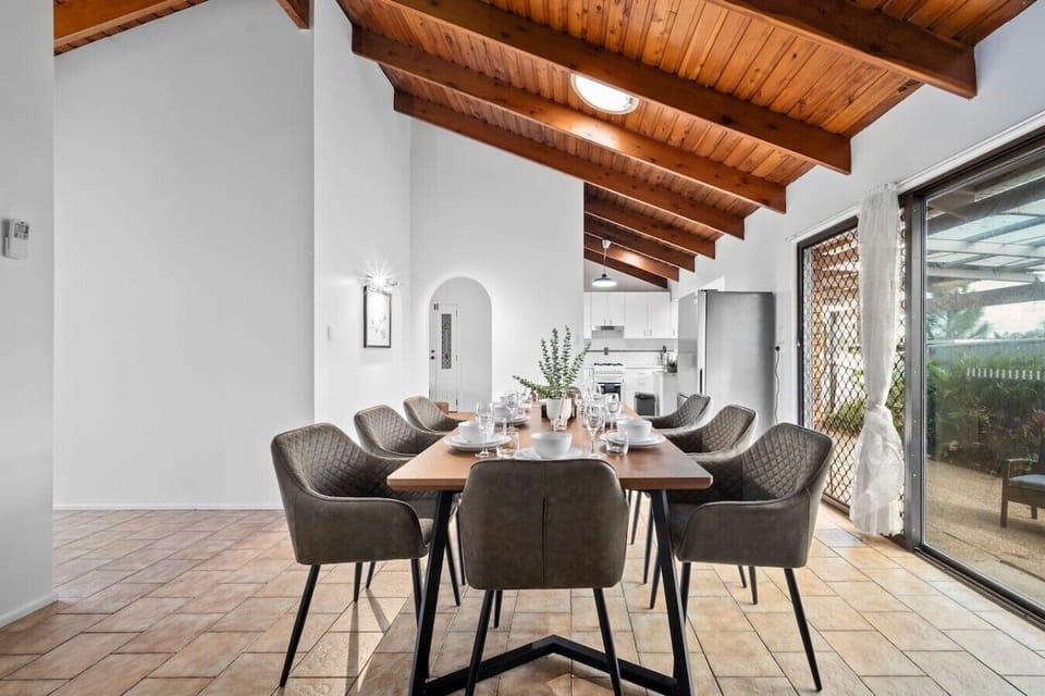 Imagine gathering with your loved ones around this stunning dining table — soaring timber ceilings, natural light flooding in, and a space that turns every dinner into an occasion.