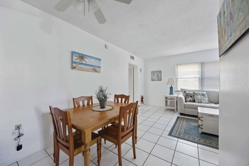 Dining area with wooden table and coastal-themed decor in a bright living space