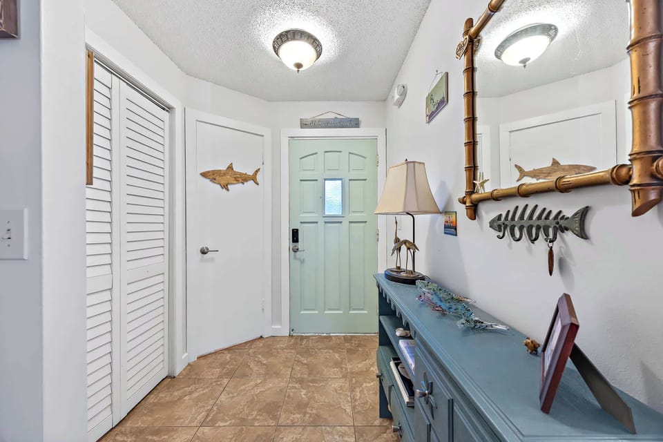 Entryway with coastal decor and a light green front door
