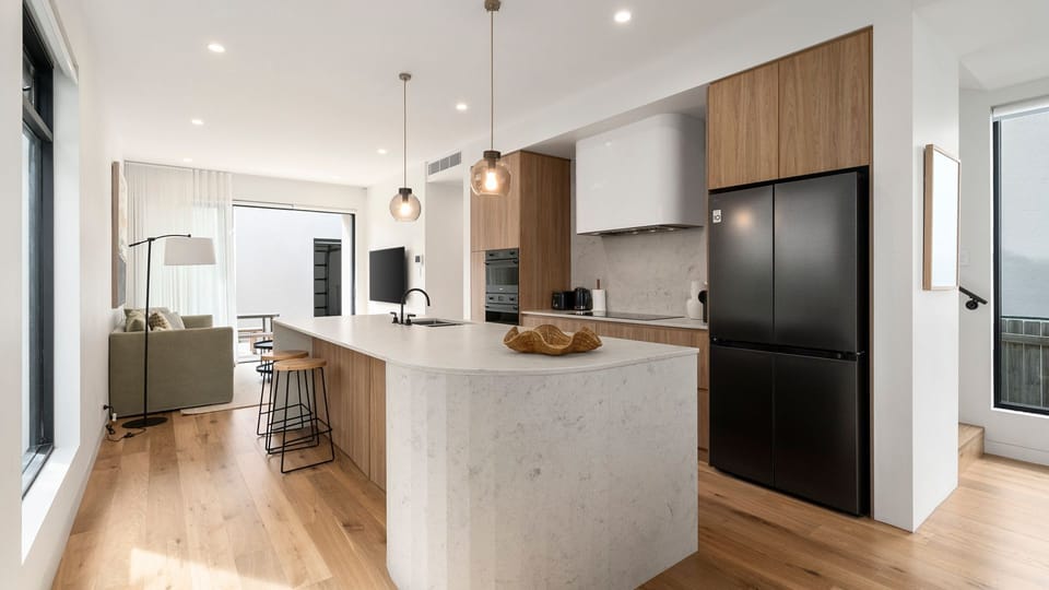 Open-plan living, dining and kitchen area with natural light and comfortable seating