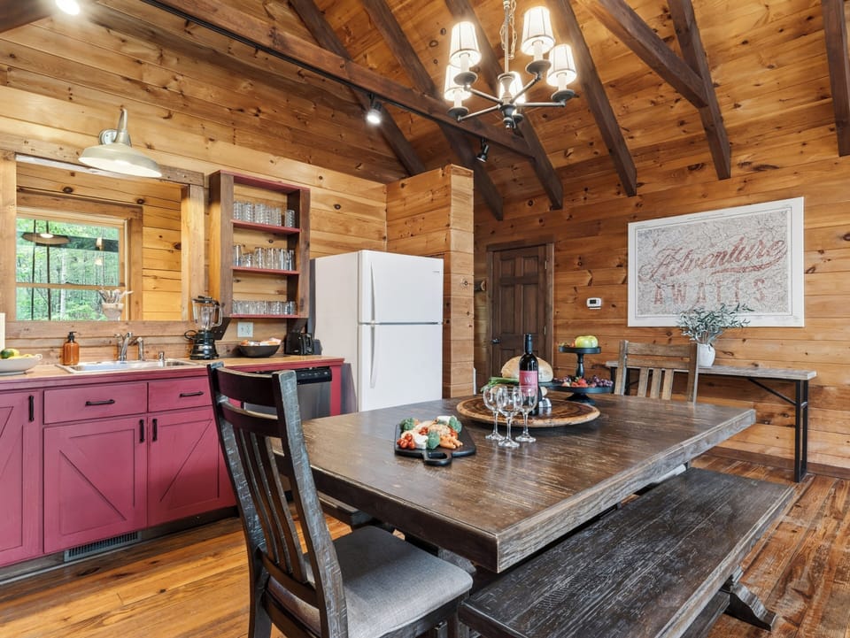 Warm cabin dining with vaulted wood ceilings, rustic charm, and a cozy fireplace nearby.