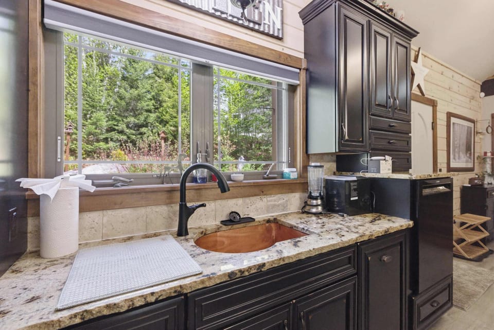 Forest views from the kitchen sink bring natural light into every meal prep.