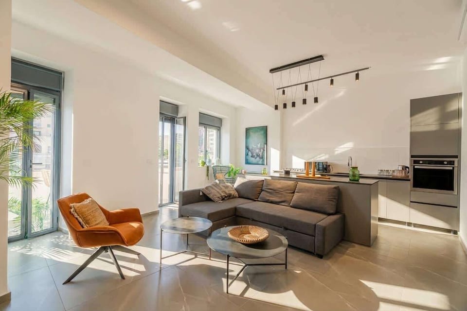 Bright open living room with a comfortable sofa, lounge chair and plenty of natural light.