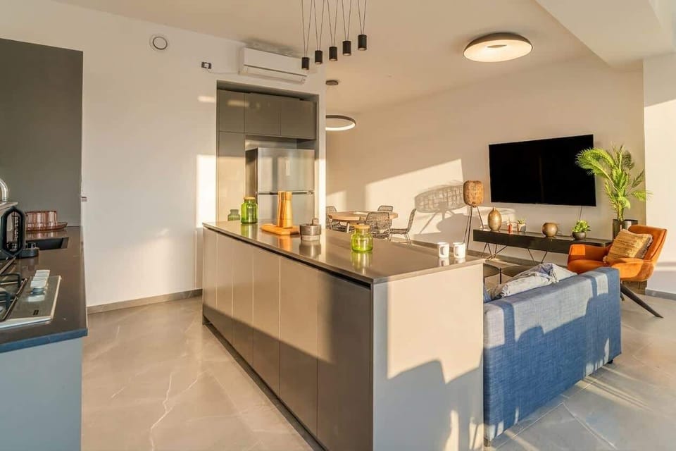 Modern open kitchen with a large island, bar stools and everything needed for easy meals at home.