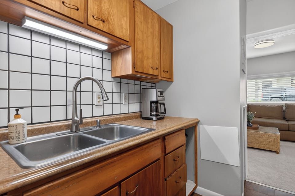 Your home-away-from-home kitchen features warm wood cabinets, a double sink, and a coffee maker ready to brew your morning cup.
