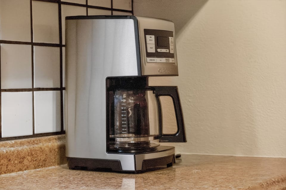 A sleek stainless steel coffee maker is ready to brew your perfect morning cup, making it effortless to start each day with fresh coffee in your home-away-from-home.