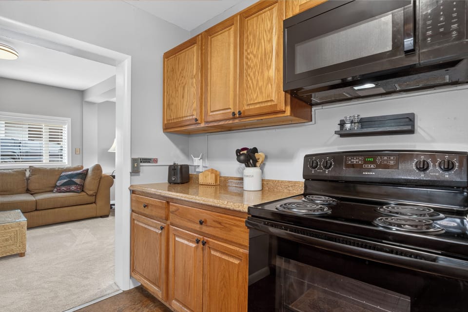 You'll love preparing meals in this fully equipped kitchen, complete with a stove, microwave, and ample counter space. The open layout connects seamlessly to the cozy living area, making it easy to relax and entertain.
