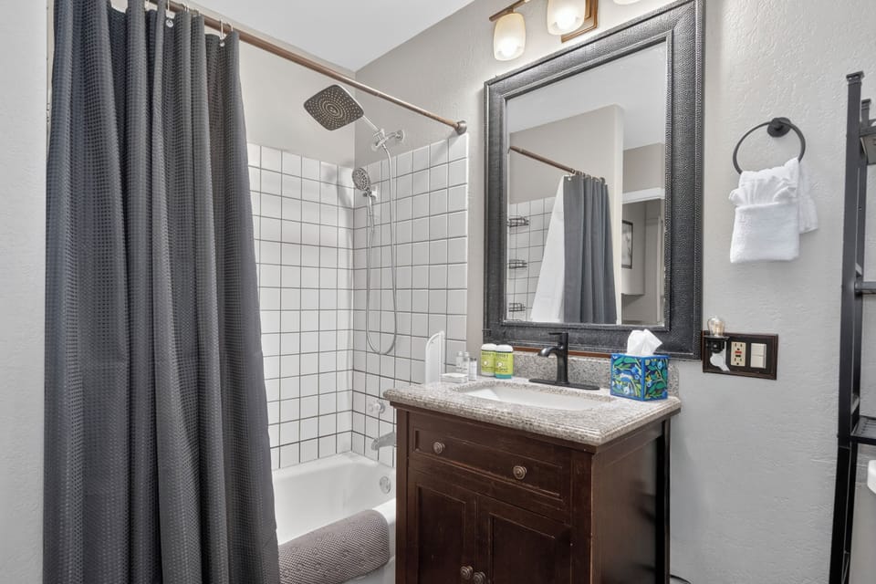 Step into your private bathroom with a refreshing shower, granite vanity, and plush towels—everything is ready for your comfort and relaxation.