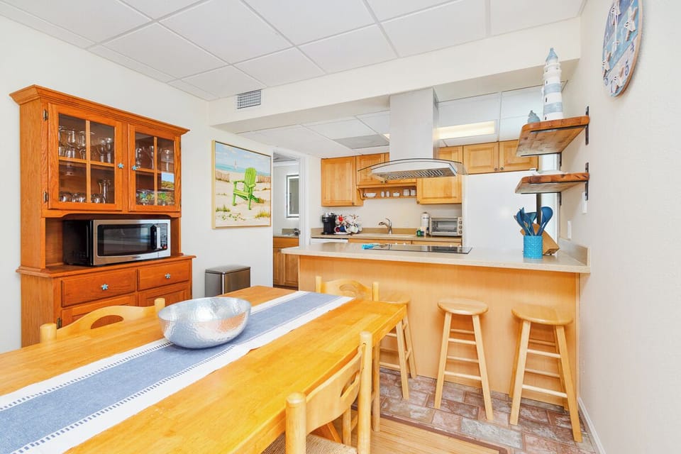 You'll love preparing meals in this bright, fully-equipped kitchen with warm wood cabinetry, stainless appliances, and a cozy breakfast bar where you can sip morning coffee.