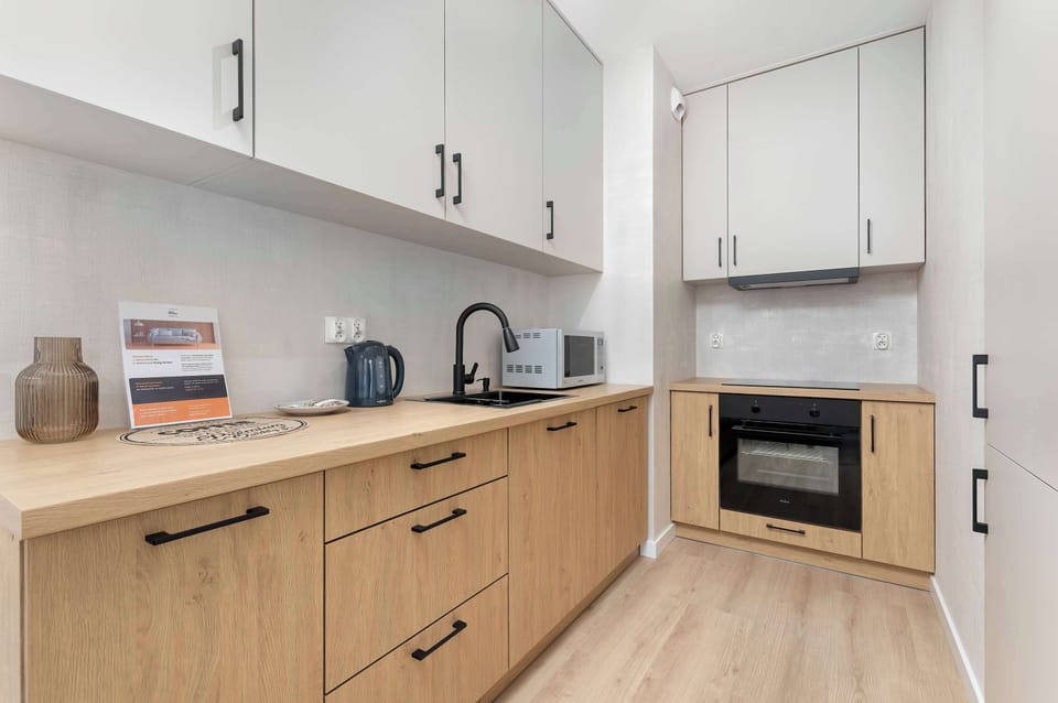A compact kitchen area with wooden cabinetry and built-in appliances. The space is modern, functional, and efficiently designed for daily use.