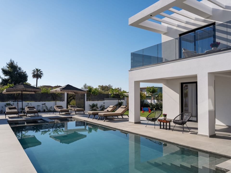 The pool area is framed by premium sunbeds, creating a serene setting for all-da