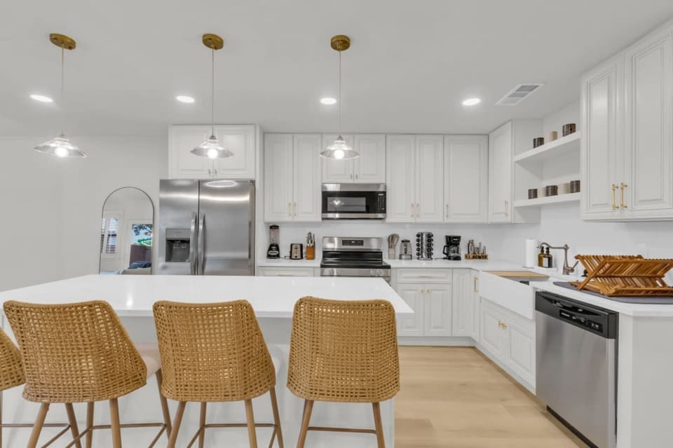 Chef-ready kitchen with dishwasher, cooking basics, dishes and cutlery, and stainless steel Frigidaire appliances. Designed for comfort during any length of stay.