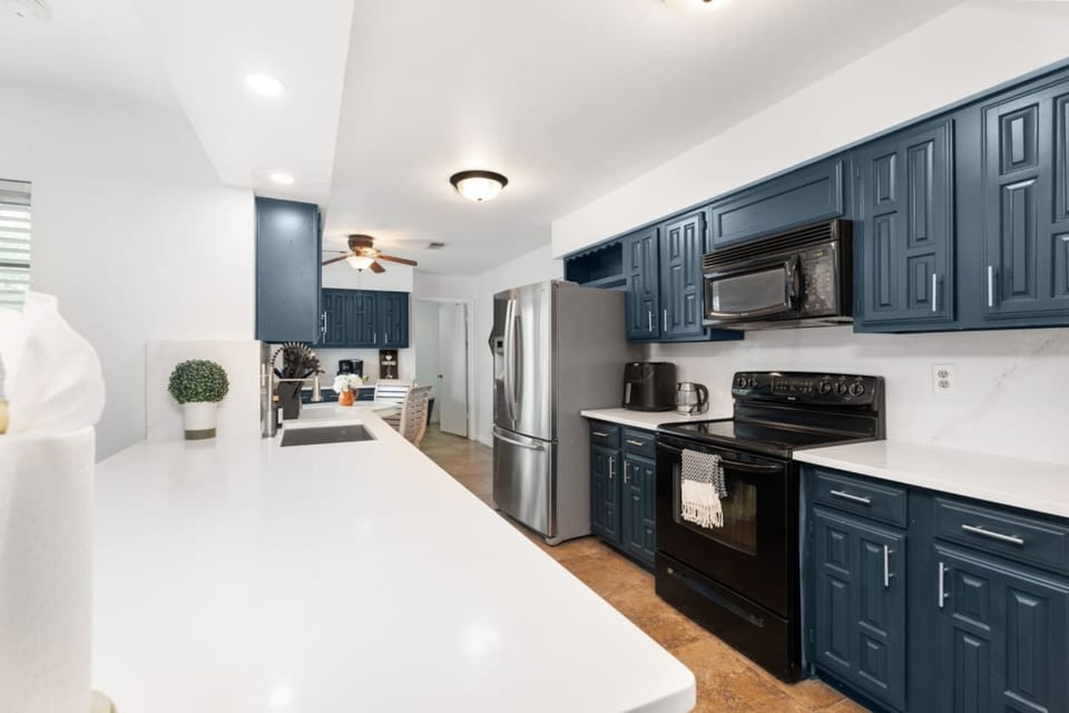 Fully equipped kitchen with stainless steel appliances and bold cabinetry.