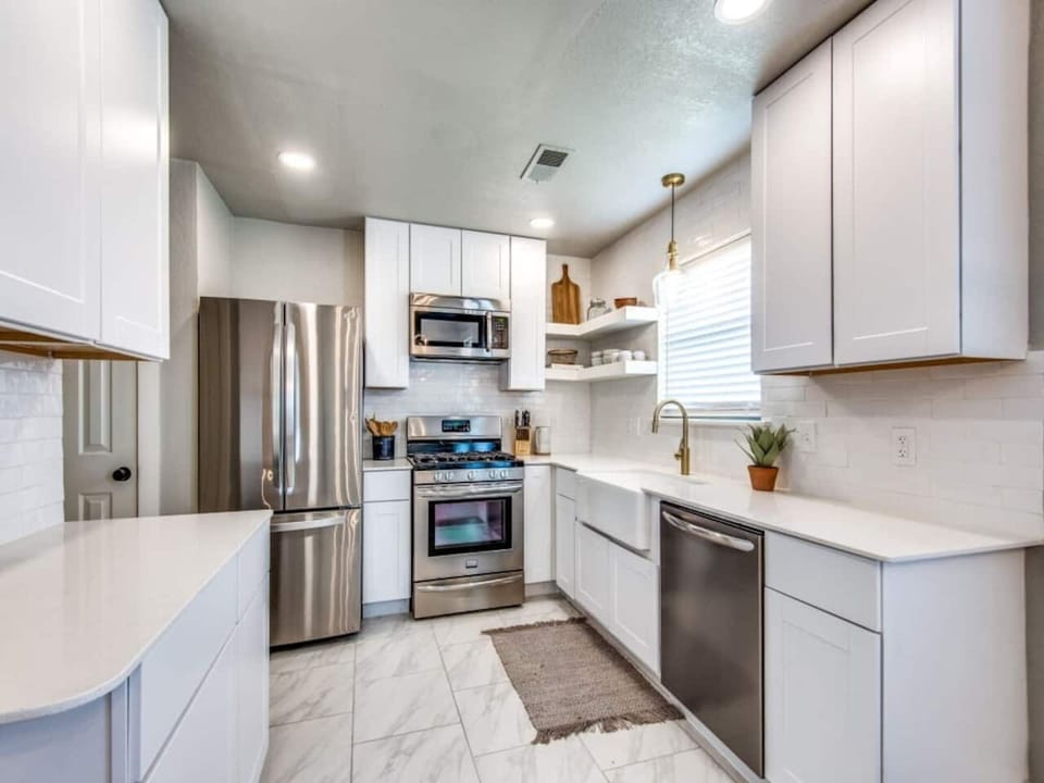 Renovated kitchen with stainless steel appliances, white shaker cabinets, and quartz countertops. Stocked with Keurig, blender, cookware, and dishes. Modern farmhouse Airbnb in Aubrey TX near Frisco, Denton, and wedding venues.