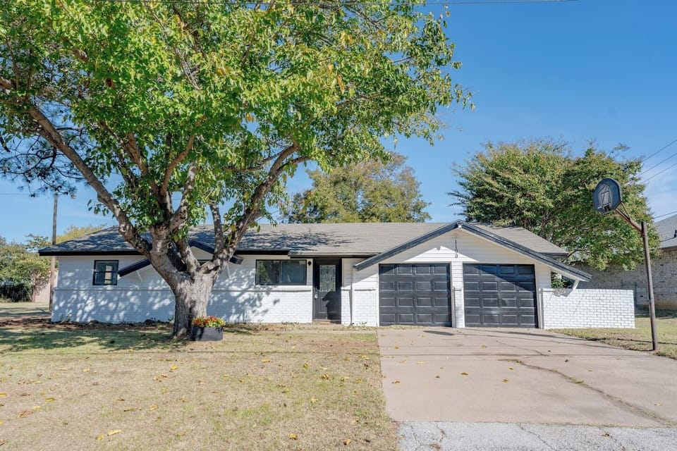 Welcoming Grand Prairie stay with a modern black-and-white exterior, wide driveway, and plenty of yard space for family fun or evening cookouts.