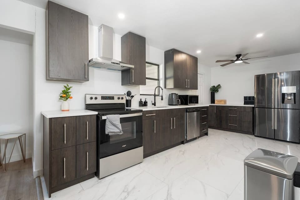 Bright and fully equipped kitchen featuring an electric stove, single oven, dishwasher, full-size fridge, Keurig coffee machine, and microwave. Complete with pots, pans, oil, salt, and pepper, this space is perfect for cooking up a storm!