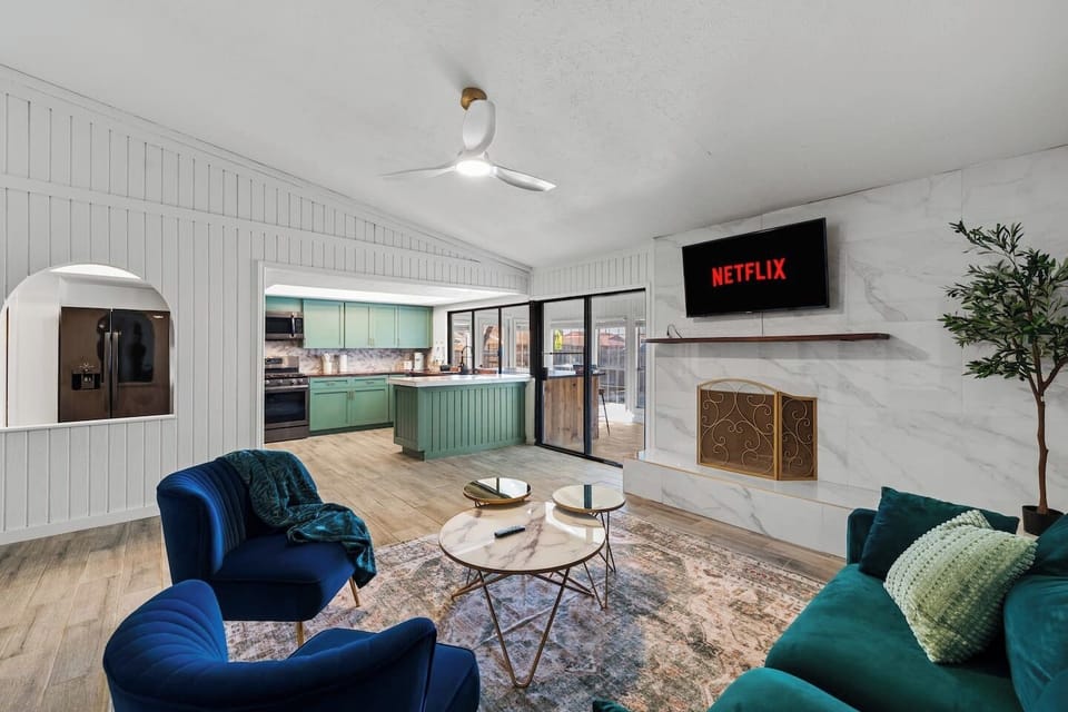 Open-concept living at its best—oversized living room with mounted TV and modern furniture flowing into the kitchen.