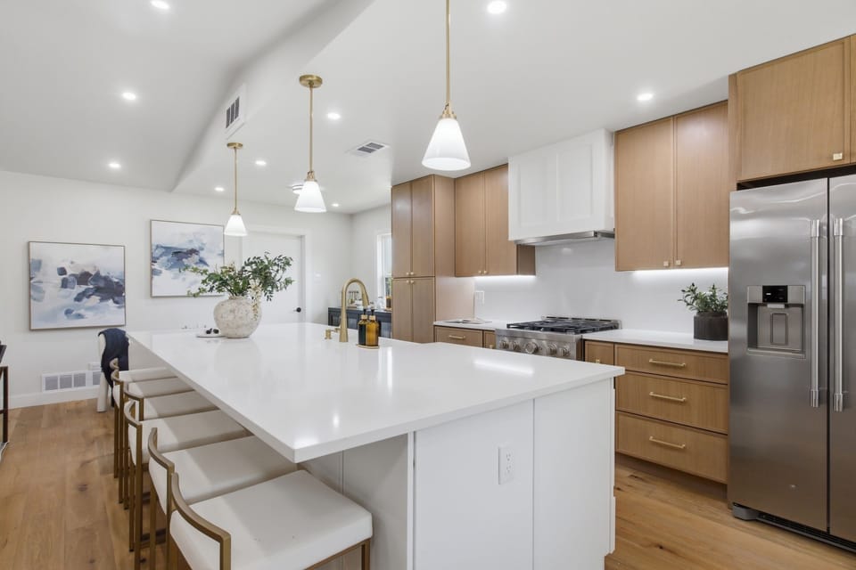 Spacious Kitchen Island with seating for four doubles as a breakfast bar. The central gathering point of this open-concept Frisco kitchen.