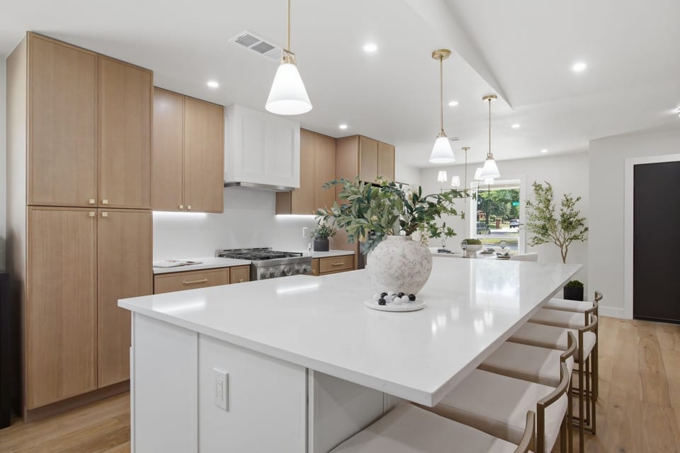 Open-Concept Kitchen flows into the dining area for seamless entertaining. Stainless Frigidaire Refrigerator, modern lighting, and tons of natural light.