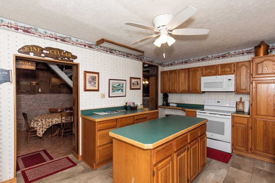 Step into a cozy kitchen with warm wood cabinetry, full appliances, and plenty of counter space for preparing your favorite meals during your stay.