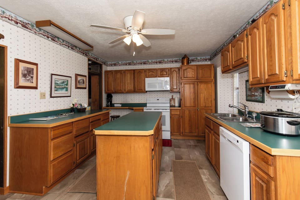 A spacious kitchen awaits with warm wood cabinetry, ample counter space, and full appliances. You'll enjoy preparing meals with plenty of room to spread out and store your ingredients.