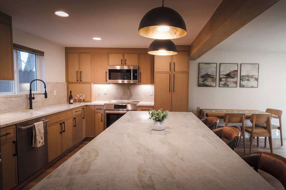 Beautifully designed kitchen and living area with breakfast bar seating for 3 people and dining seating for 4.