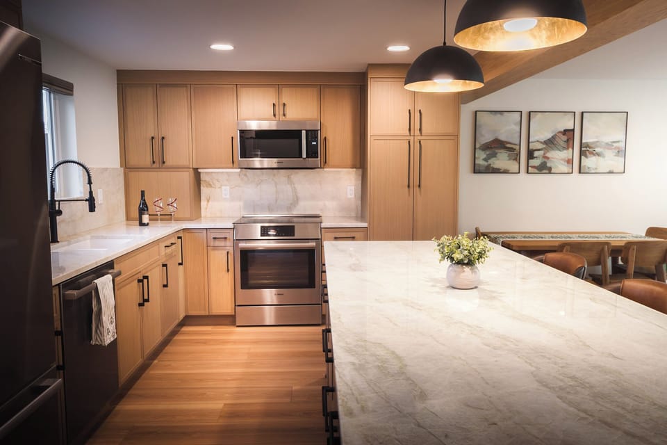 Beautifully designed kitchen and living area with breakfast bar seating for 3 people and dining seating for 4.