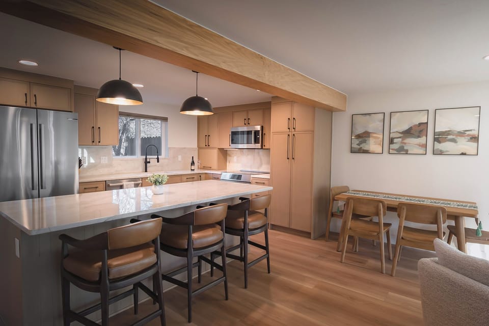 Beautifully designed kitchen and living area with breakfast bar seating for 3 people and dining seating for 4.