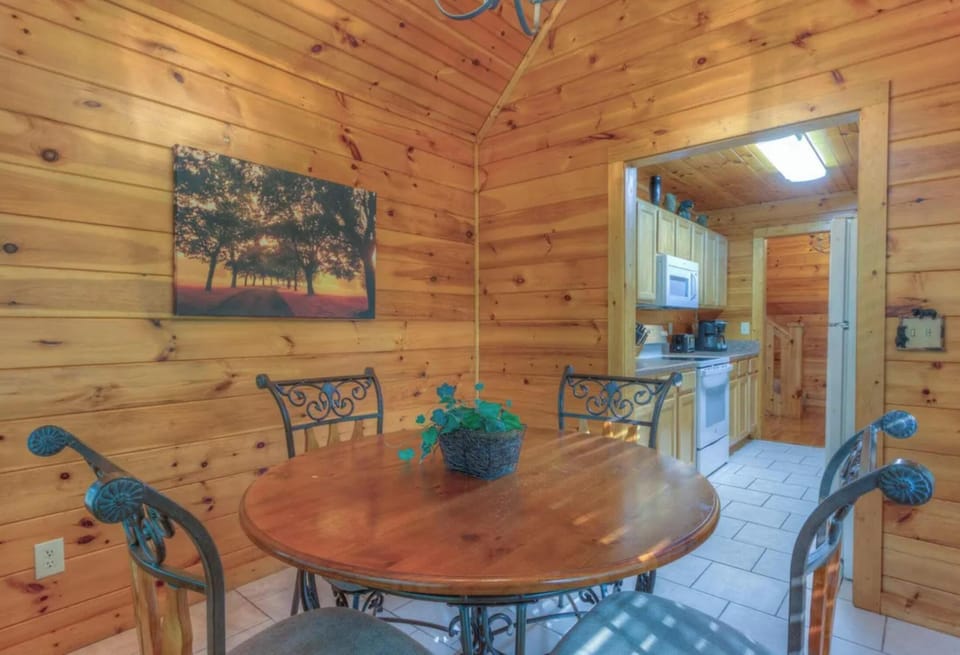 Gather around the warm wood-paneled dining area, where natural light brightens your meals and conversation flows easily from table to kitchen.