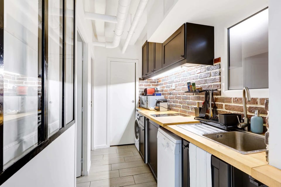 Cuisine équipée : micro-ondes, lave-linge, plaque de cuisson, machine à café, lave-vaisselle, grille-pain
