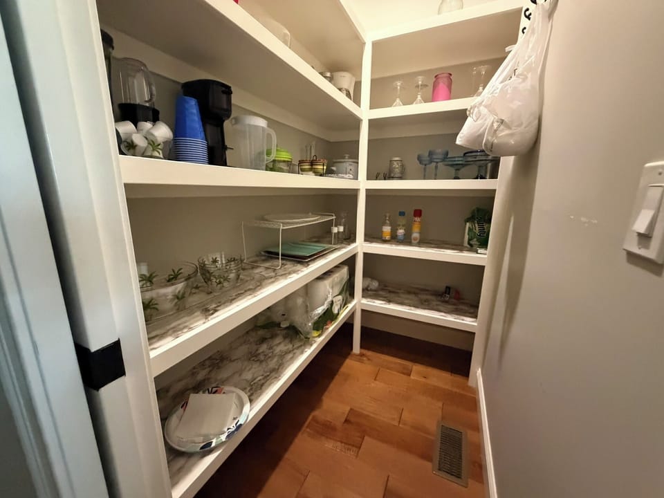 A well-organized walk-in pantry with open shelving keeps all your essentials within easy reach, making it simple to stock up and settle in for your stay.