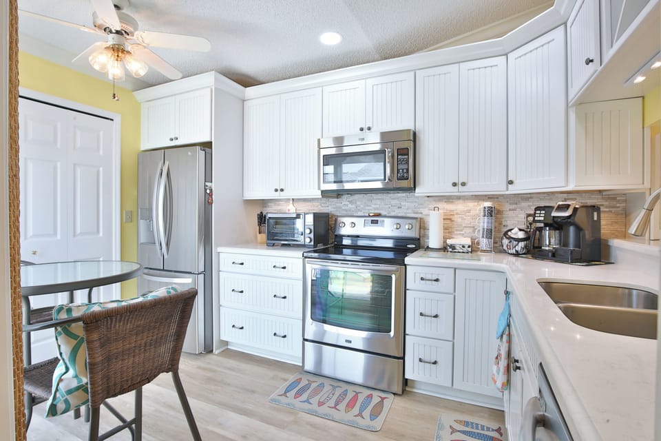 Your well-equipped kitchen invites you to prepare meals with ease, featuring stainless steel appliances, ample counter space, and bright white cabinetry that create a fresh, welcoming atmosphere.