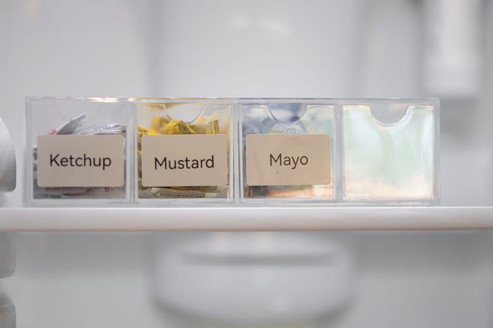 Thoughtfully stocked fridge drawer with labeled ketchup, mustard, and mayo for easy guest use.