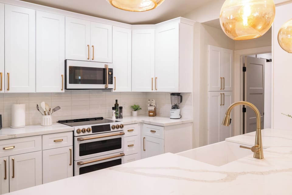 Chef's kitchen with quartz island, gold hardware & premium appliances