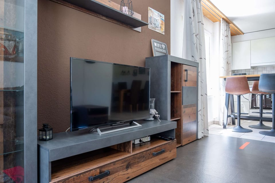 Living room with TV, media unit and open layout toward the dining area
