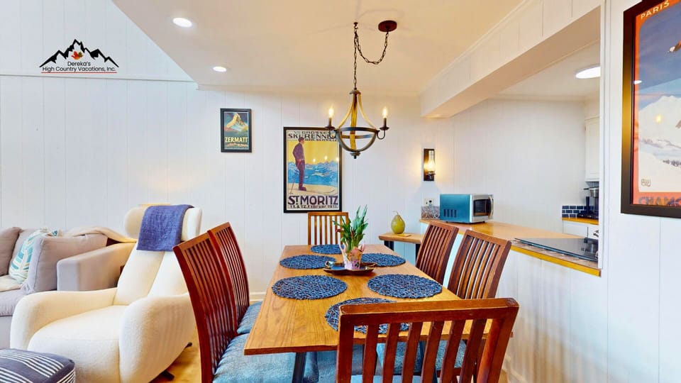 Picture yourself gathering here for memorable meals at your cozy mountain retreat with vintage ski posters and warm lighting.