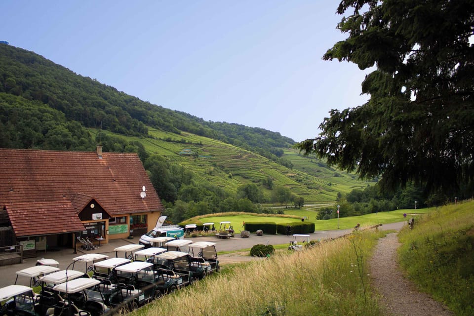 The clubhouse is the social heart of the golf estate, surrounded by lush fairways and vineyard-covered hills.