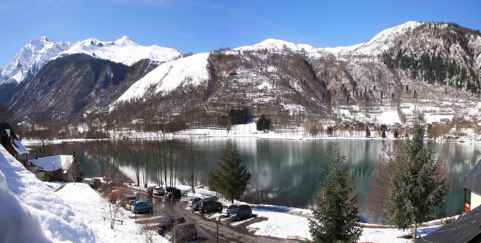 The frozen lake and surrounding peaks highlight La Soulane’s unique location in the Louron Valley, where nature and ski escapes meet.