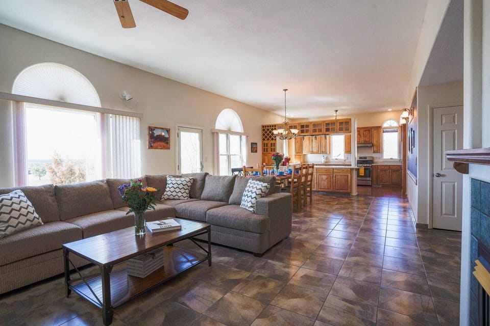Spacious open-concept living area perfect for family gatherings, featuring a cozy sectional sofa, dining space, and a full kitchen.