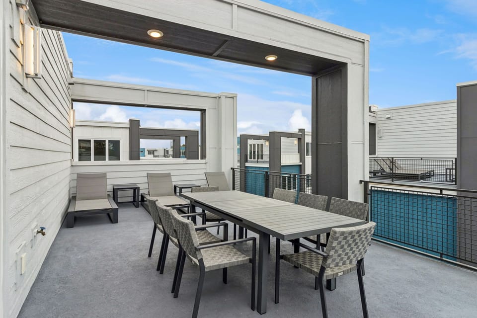 Expansive covered balcony with outdoor dining and lounge seating for the whole group