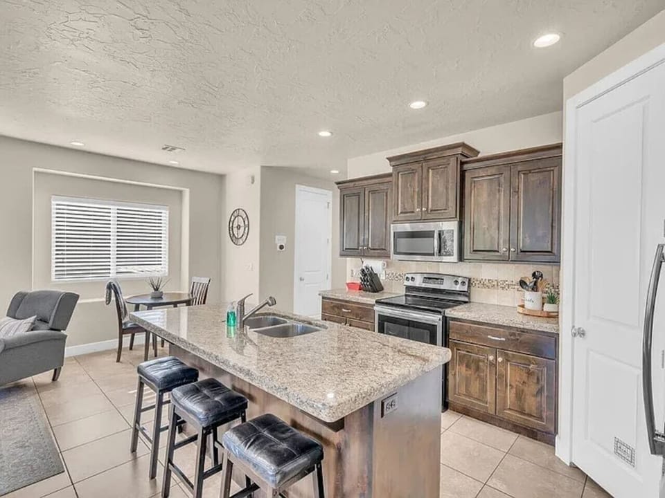 Spacious kitchen with island, bar seating, and stainless steel appliances