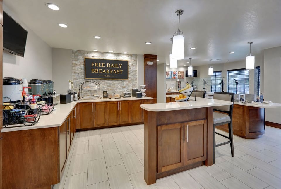 Free Daily Breakfast! A dining area showcases a buffet setup with fresh fruit.