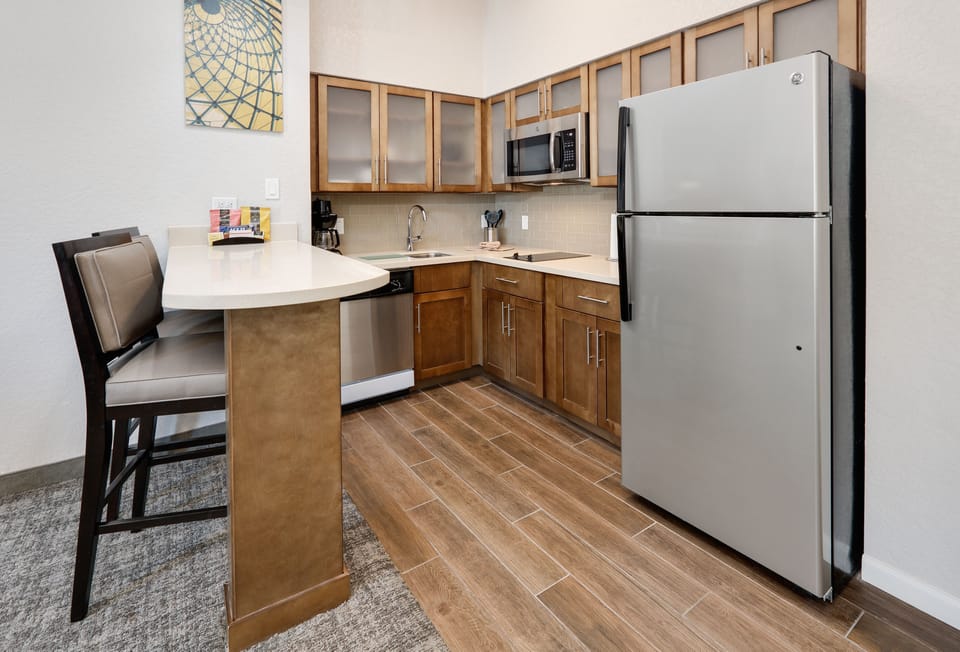Fully equipped kitchen with stainless steel appliances and bar seating.