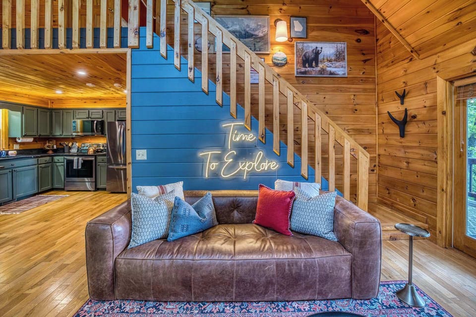 The ultimate cozy corner. Sink into the plush leather sofa, framed by a striking blue accent wall and our signature "Time to Explore" neon sign. It’s the perfect spot to map out your daily adventures or curl up with a good book.