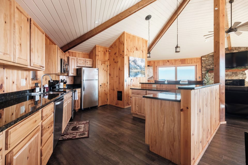 Bright, open kitchen flows into the main living space with mountain views and vaulted ceilings. Great setup for groups to cook, snack, and gather together.
