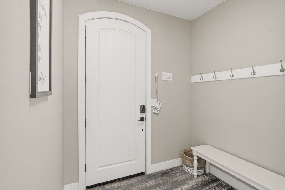 Entryway with bench, wall hooks, and convenient storage space.