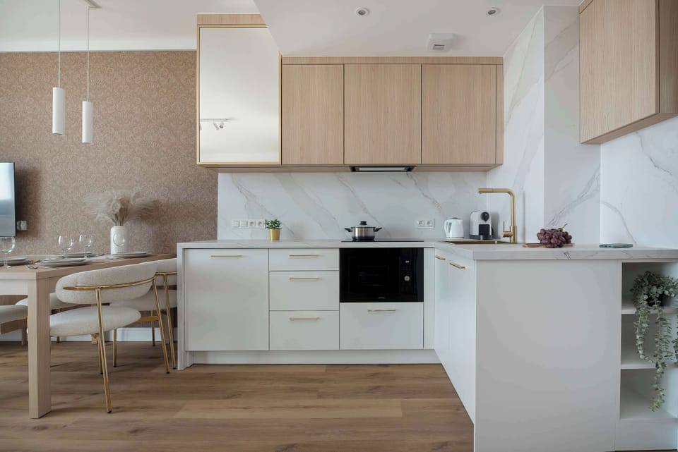 Fully equipped kitchenette with modern appliances, built-in oven, stovetop, microwave, and dining space.