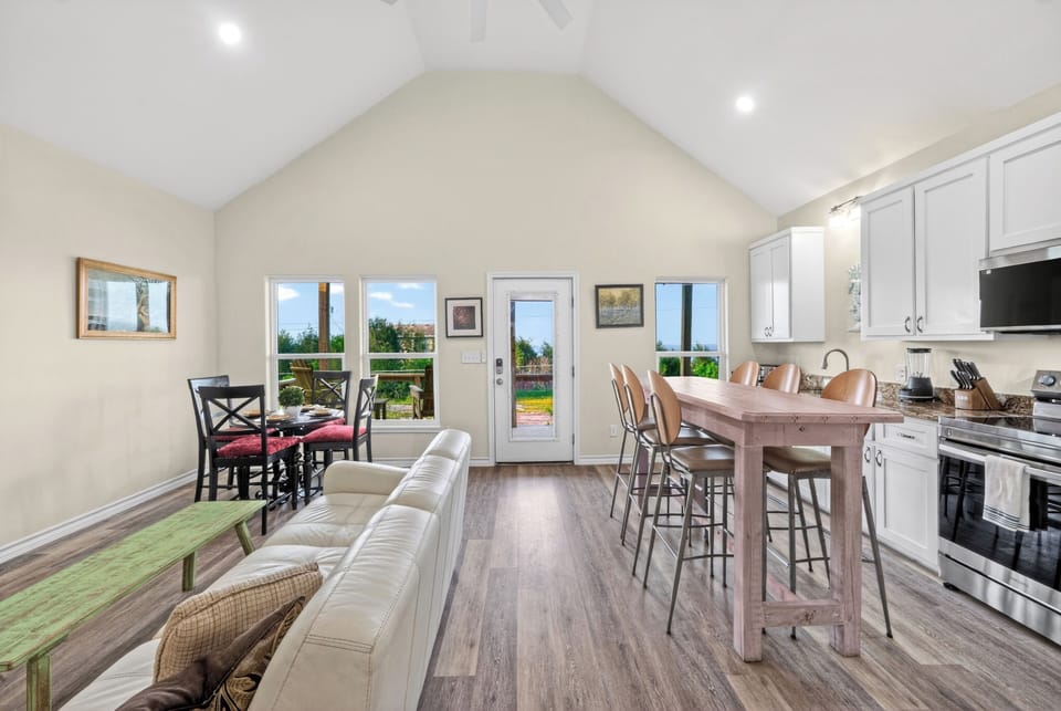 Sun-drenched open-concept living space featuring vaulted ceilings and seamless indoor-outdoor flow.