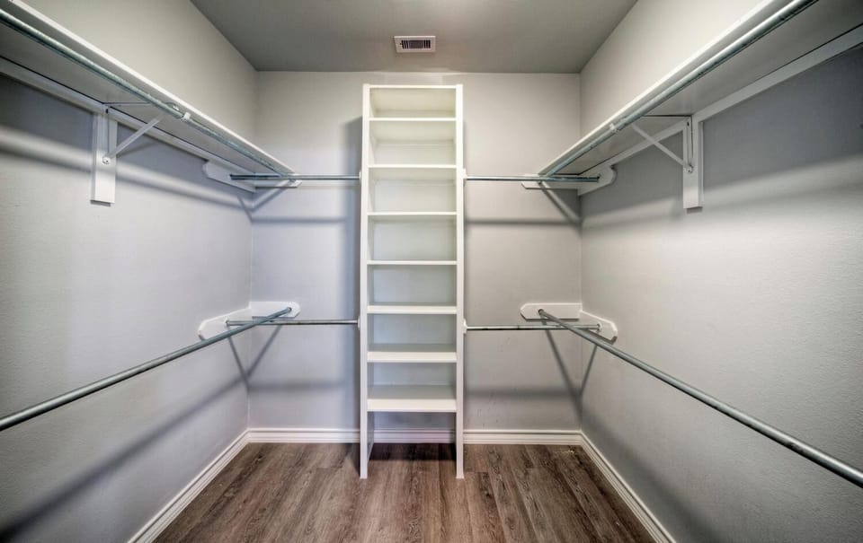 Organized walk-in closet with built-in shelving.