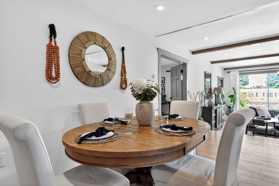 Symmetry and style. A dedicated dining space anchored by a statement round wooden table and chic woven wall decor.